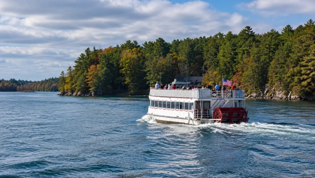 Sightseeing boat cruising past wooded islands on the 2 Nation Tour in the Thousand Islands