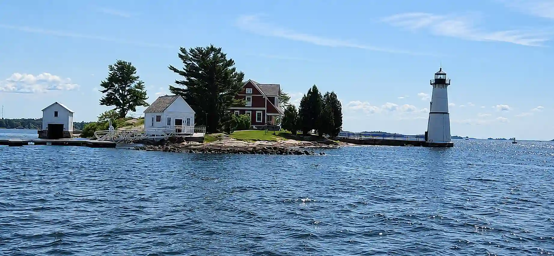 Narrated cruise boat passing a lighthouse and wooded islands on the St. Lawrence River at dusk