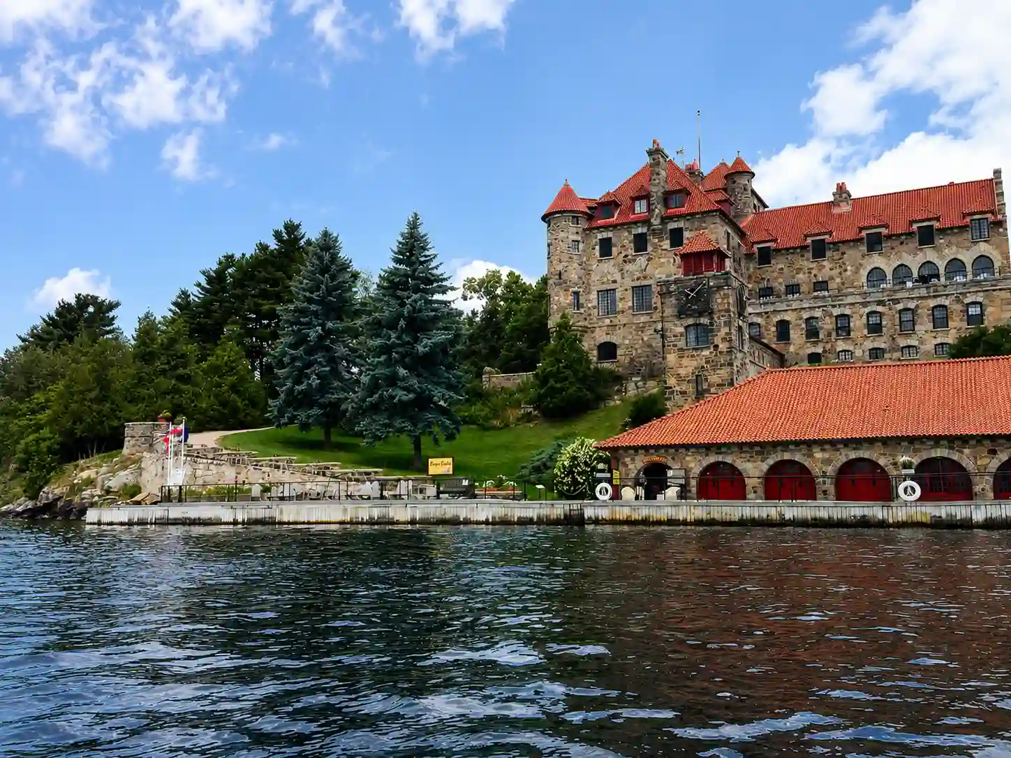 Ivy-covered granite castle with towers on a wooded island under a soft grey sky